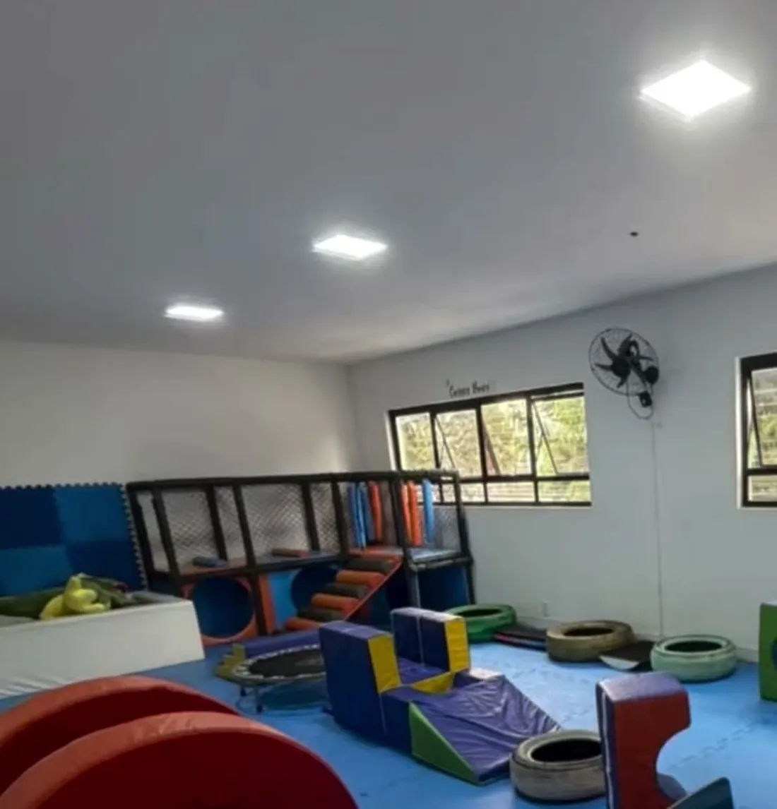 Sala de atendimento com colchonetes, cones e cama elástica